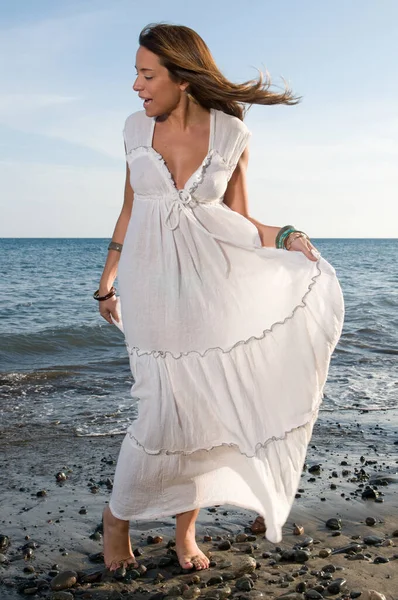 日落时穿着白色衣服欣赏大海的漂亮女人 — 图库照片