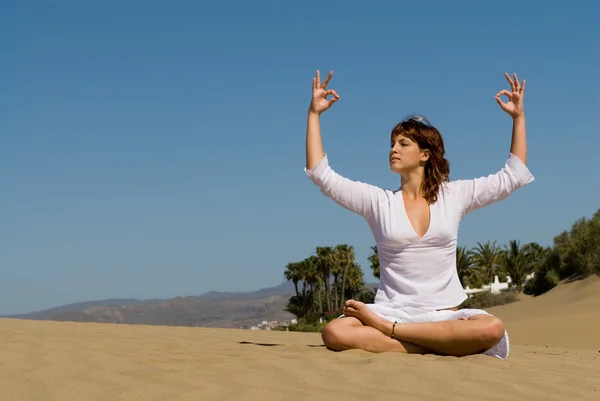 Vrouw in het zand ontspannen en in meditatie positie — Stockfoto