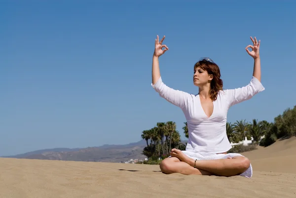 Vrouw in het zand ontspannen en in meditatie positie — Stockfoto