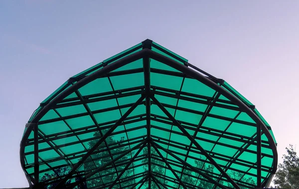 The corner of the canopy above the entrance to the city park against the sky. Background.