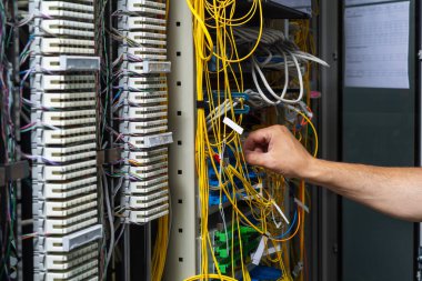 Telekomünikasyon panelinden geçen bir teknisyenin elleri.