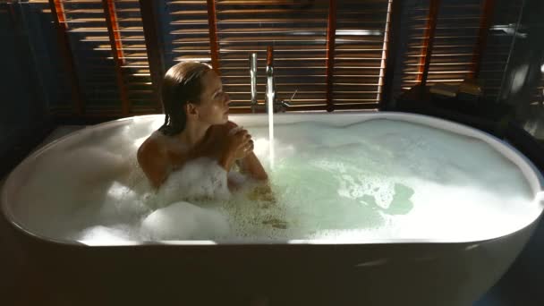 Smiling Sensual Woman Relaxing in Bathtub with Flowing Water in Sun Rays — Stock Video