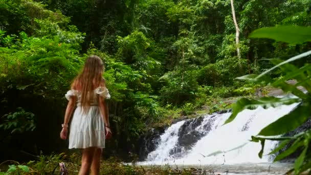 Mujer viajera caminando frente a la cascada Cascada Tropical, disfrutando de la naturaleza — Vídeos de Stock