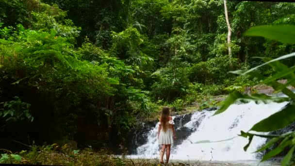 Mujer viajera caminando frente a la cascada Cascada Tropical, disfrutando de la naturaleza — Vídeos de Stock