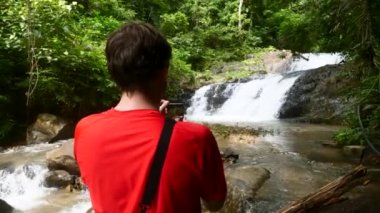 Şelalede Gezgin Adam, Tayland 'da Cep Telefonu' nda Fotoğraf Çekiyor