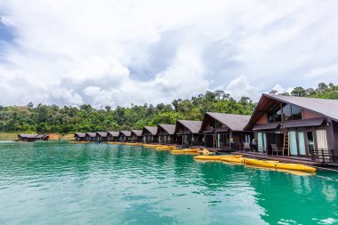Yeşil Göl 'de yüzen salt evleri ve tropik ağaçlarla dolu lüks bir tatil köyü.