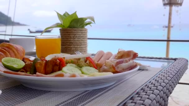 Stół z luksusowym pięknym śniadaniem, kawa, sok z tropikalnym widokiem na morze — Wideo stockowe