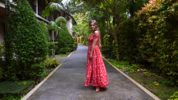 Mujer feliz sonriente viajando caminando y mirando la cámara en Tropical Resort — Vídeo de stock