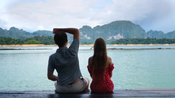 녹색 산맥의 우든 다리에 함께 앉아 있는 행복 한 낭만적 인 부부 — 비디오