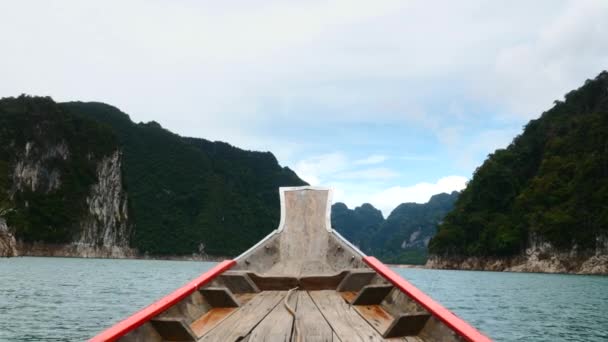 Viajando en barco de madera un lago azul con acantilados de piedra caliza y selva tropical verde — Vídeo de stock