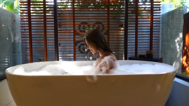 Belle femme relaxante dans une baignoire en mousse. Soulager le stress Spa Relaxation dans l'hôtel — Video