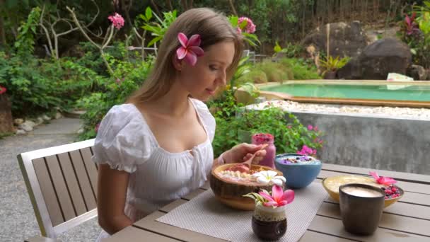吃早餐的年轻女人阿凯碗。女人吃油腻碗 — 图库视频影像