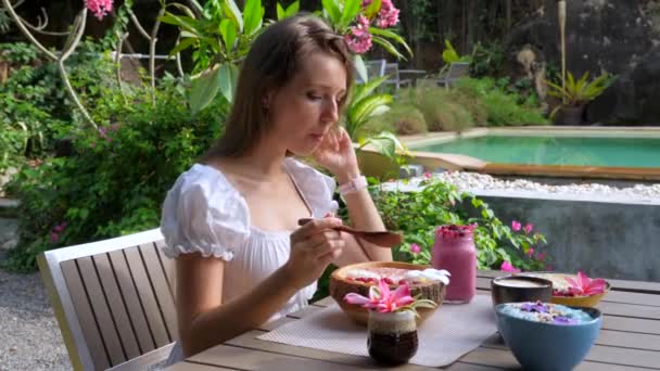 Happy Souriant Femme Manger Vegan Petit déjeuner Acai Bowl au café en plein air — Video