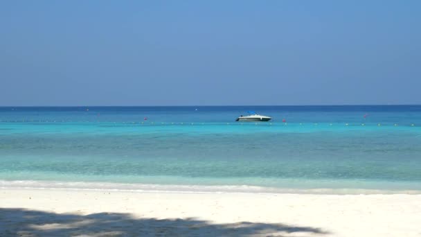 Краєвид на пляж з чистою бірюзовою морською водою і човном — стокове відео