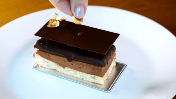 Chef Woman Hand Coloca una avellana en los postres de la Opera Cake en el restaurante — Vídeos de Stock