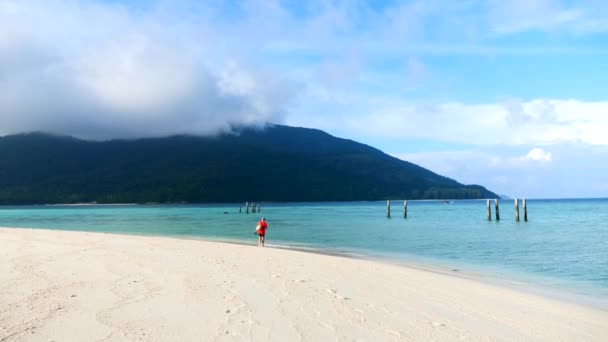 Turista uomo in rosso T-shirt in vacanza sul mare blu a piedi sulla costa — Video Stock
