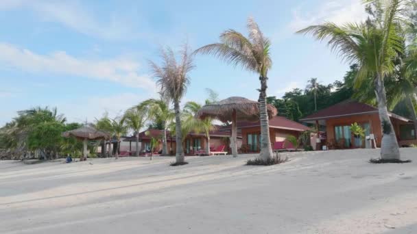 Туристический тропический курорт на пляже с белым песком, пальмами и синим морем — стоковое видео