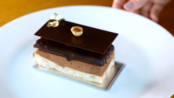 厨师女士在餐馆里的歌剧蛋糕甜点上放了一个榛子 — 图库视频影像