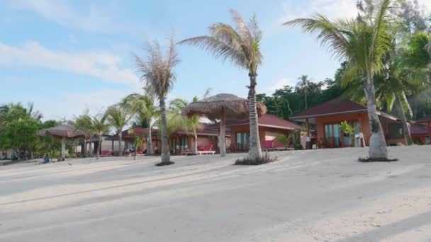 Туристический тропический курорт на пляже с белым песком, пальмами и голубым небом — стоковое видео
