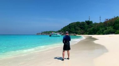 Beyaz Kum ve Mavi Deniz 'le Covid sırasında Boş Sahilde Yürüyen Turist