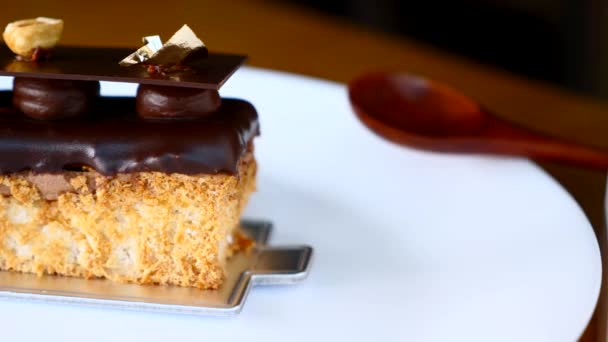 在歌剧蛋糕甜点附近的白盘上放木勺的特写 — 图库视频影像