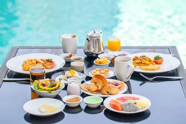 Американский завтрак на столе рядом с бассейном на курорте — стоковое фото