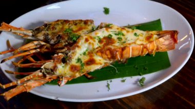 Bitkilerle ızgara ıstakoz yemeği ve akşam yemeği tabağında fırında peynir.