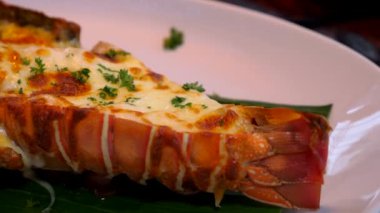 Bitkilerle ızgara ıstakoz yemeği ve akşam yemeği tabağında fırında peynir.