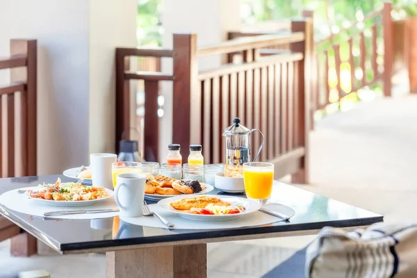 Mesa de desayuno para dos en el hotel con la placa llena de comida — Foto de Stock