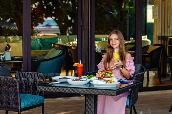 Femme ayant le petit déjeuner relaxant boire du jus de fruits frais dans un complexe de luxe — Photo