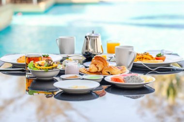 Resort 'taki havuz kenarındaki masaya Amerikan Kahvaltı Seti