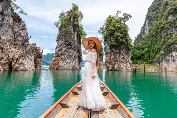 Seyahat eden kadın, Tayland 'daki Khao Sok Parkı' nda ünlü üç kayanın yanında oturuyor.