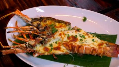 Bitkilerle ızgara ıstakoz yemeği ve akşam yemeği tabağında fırında peynir.