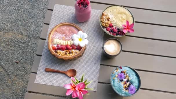 Comer desayuno vegano saludable en el Café al aire libre. Mesa con batido de Acai — Vídeos de Stock