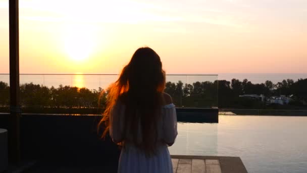 Mouvement lent de la femme en robe marchant pour voir beau coucher de soleil avec vue sur la mer — Video