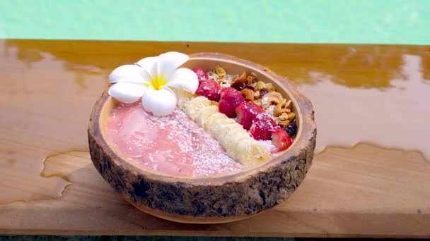 Acai Smoothie Bowl banaanilla, mansikoilla, myslillä ja kookoshiutaleilla — kuvapankkivideo