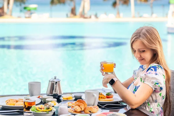 Mosolygós nő az amerikai reggeli ivás Orange Juice mellett Poolside — Stock Fotó