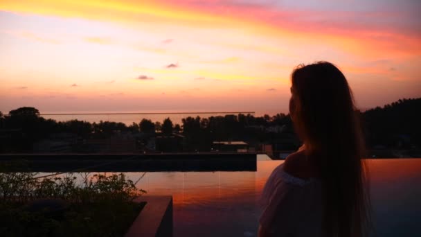 Σιλουέτα της γυναίκας Κοιτάξτε πολύχρωμο φωτεινό πορτοκαλί ηλιοβασίλεμα στο παρασκήνιο — Αρχείο Βίντεο
