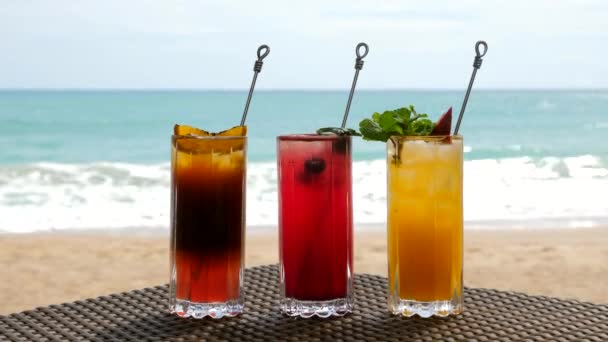 Set of Refreshing Fruit Cocktails Standing on Table on Beach near Turquoise Sea — Stock Video