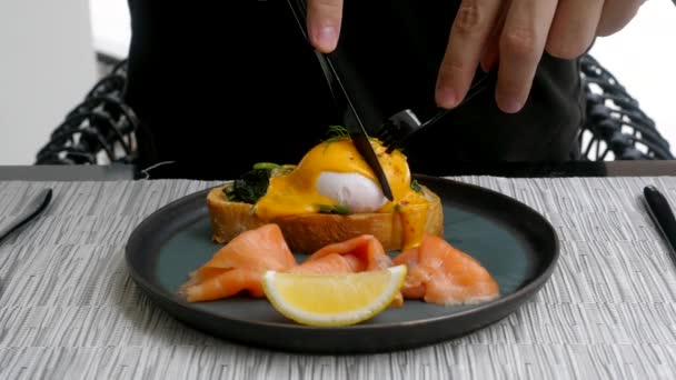 Eieren Benedictus met brood, spinazie en zalm met citroen op zwarte plaat — Stockvideo