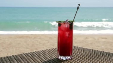 Taze kırmızı böğürtlenler Plaj Masasında Kokteyl, Arka planda Odaklanmamış Turkuaz Denizi