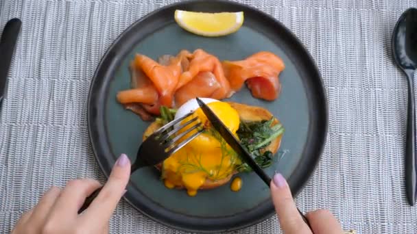 Top View of Woman Hands Skär Poached ägg med rökt fisk i restaurangen — Stockvideo