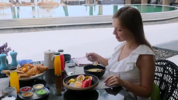 Colazione al Luxury Hotel. Sorridente donna mangiare frutta esotica al mattino — Video Stock