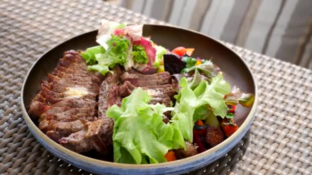 Friss pörkölt marhahús T-bone steak salátával és zöldséggel tálcán az étteremben — Stock videók