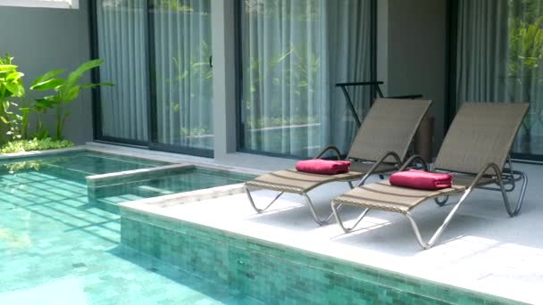 Relaks i wypoczynek w willi z dwoma leżakami w pobliżu basenu w gorący letni dzień — Wideo stockowe