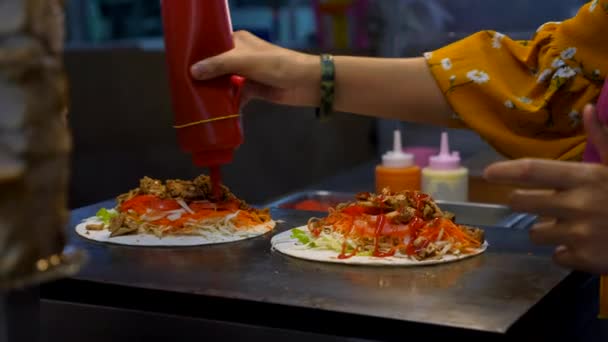 Două femei gătit pui Kebab Wrap, Adăugați sos pe Tortilla pe piața de noapte — Videoclip de stoc