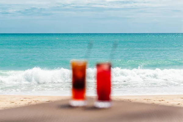 Cocktails exotiques flous et déconcentrés sur la table par la mer, Vacances en Paradis Concept — Photo