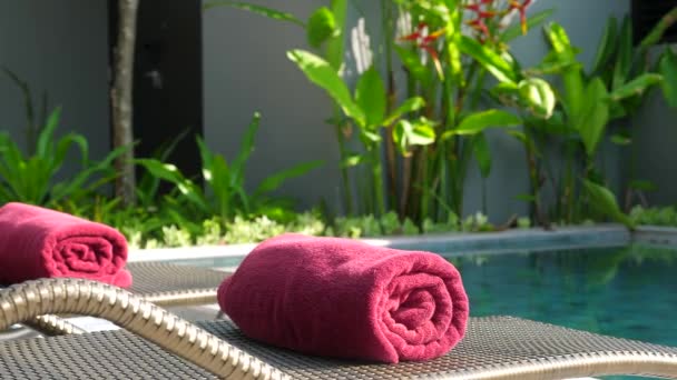 Primer plano de toallas de playa laminadas rojas en tumbonas cerca de la piscina — Vídeo de stock