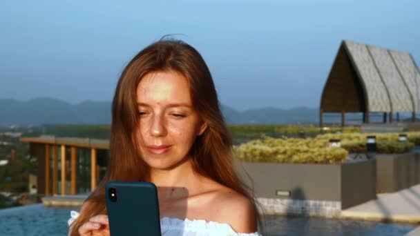 Νεαρή Travel Woman, στέκεται στην οροφή του πολυτελούς ξενοδοχείου στο ηλιοβασίλεμα καλοκαιρινή βραδιά — Αρχείο Βίντεο