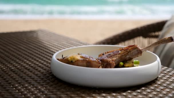 Frisch gegrilltes Lammsteak auf weißem Teller im Outdoor-Restaurant am Sommertag — Stockvideo